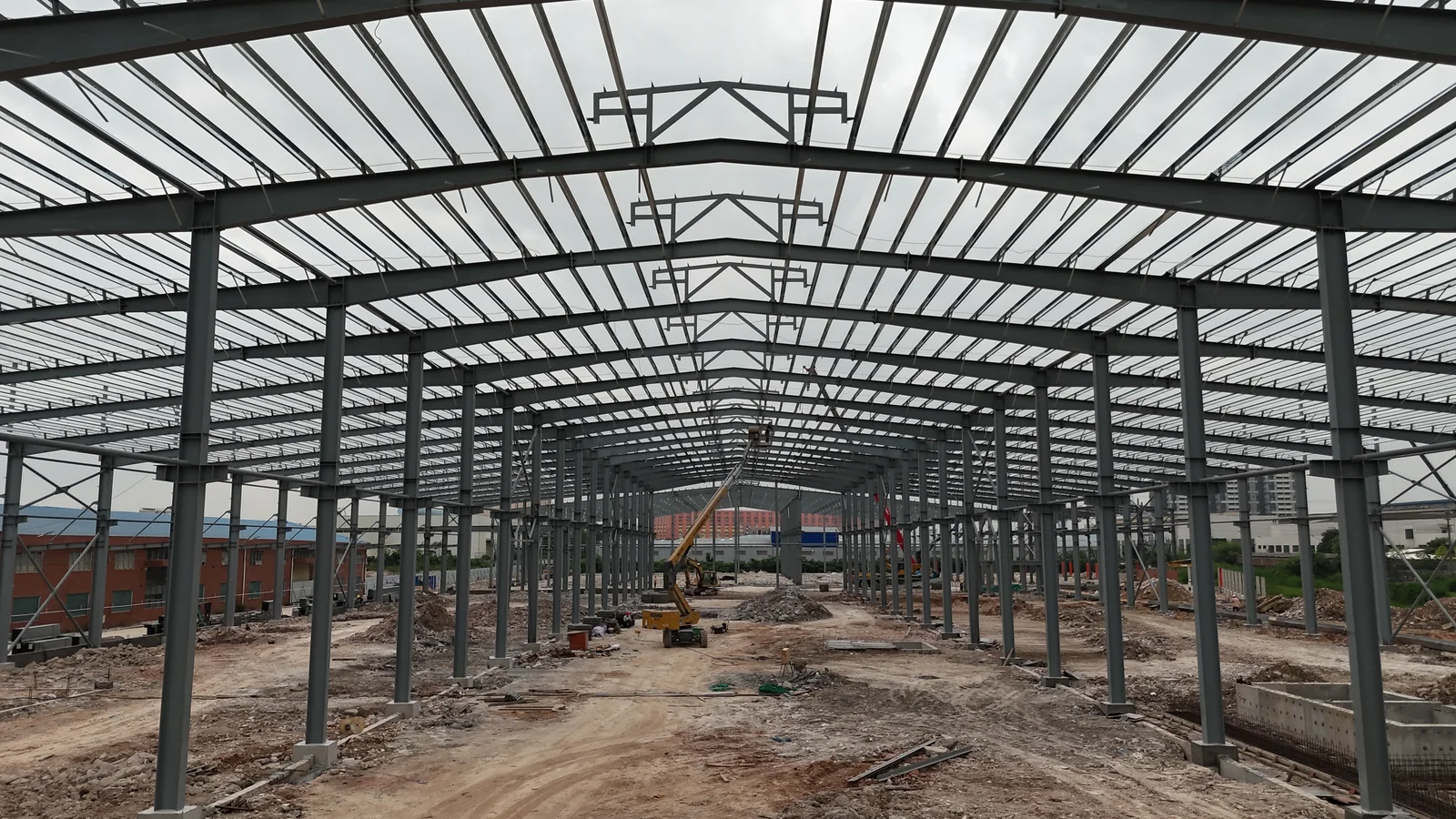 Interior view showing steel roof beams and columns at the Foshan Dekuo factory construction site.