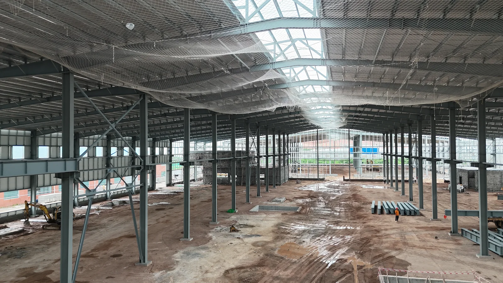 Wide interior view of steel columns, roof structure and roofing at the Foshan Dekuo factory.