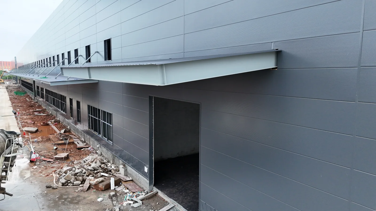 Closer view of the exterior wall and large entrance of the Foshan Dekuo factory during construction.