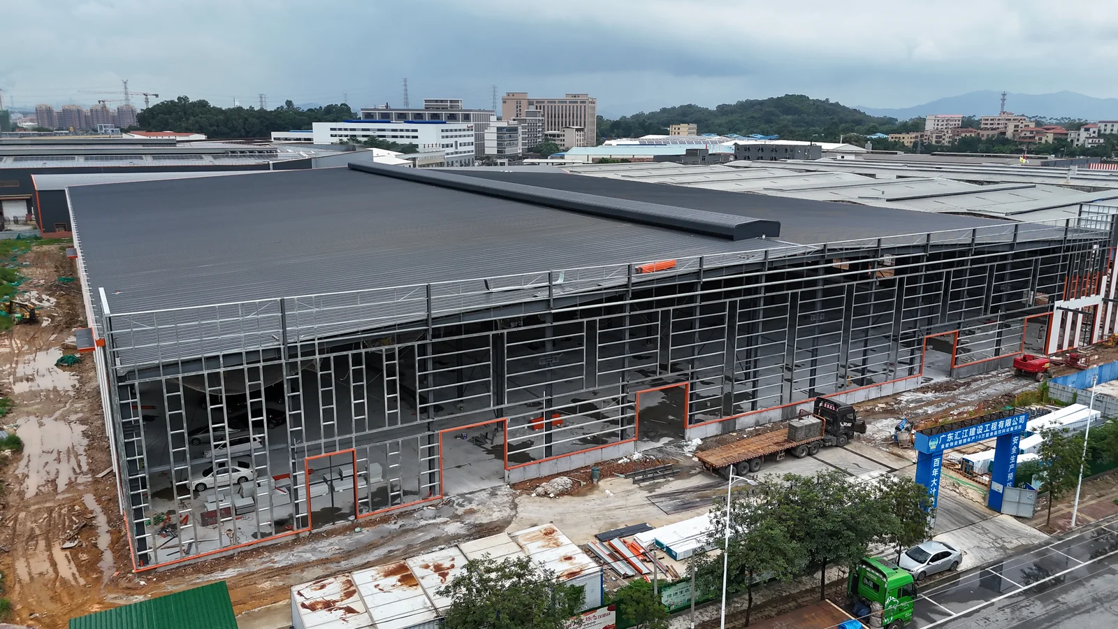 Elevated aerial view of the Foshan Dekuo steel structure factory with roofing and exterior construction work visible.