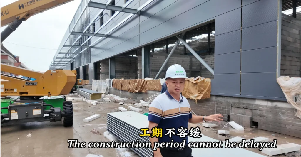 Steel structure construction site showing wall panel installation and schedule control