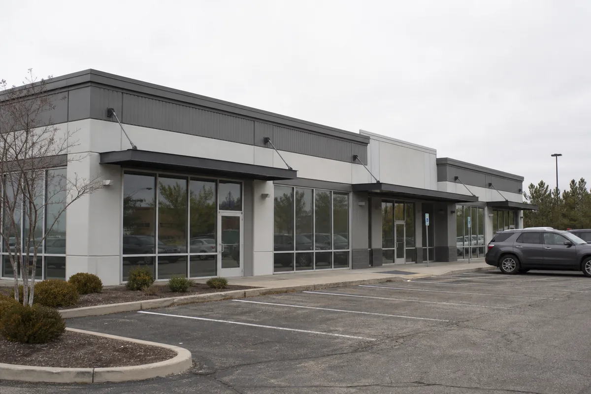 Real steel retail commercial building exterior with glass storefronts and entrance canopies