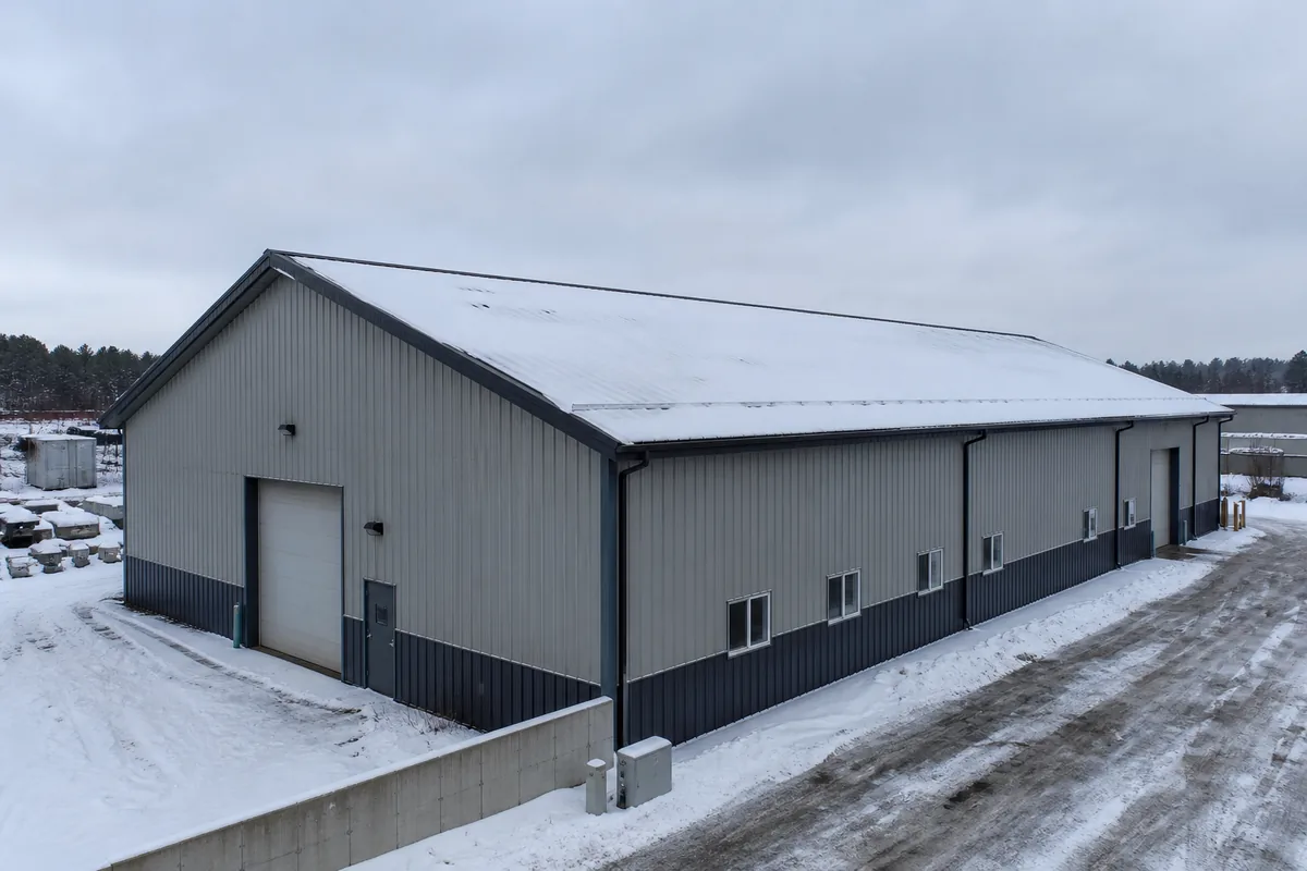 Industrial steel building designed for snow load on a sloped metal roof